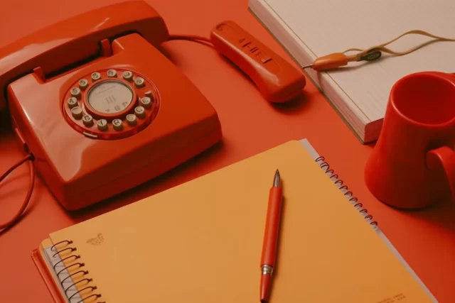 彩色背景上的复古手机和笔记本