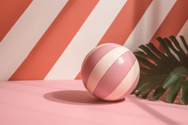 粉红色台面上的玩具球: 池子和海滩肖像的色块热带象征